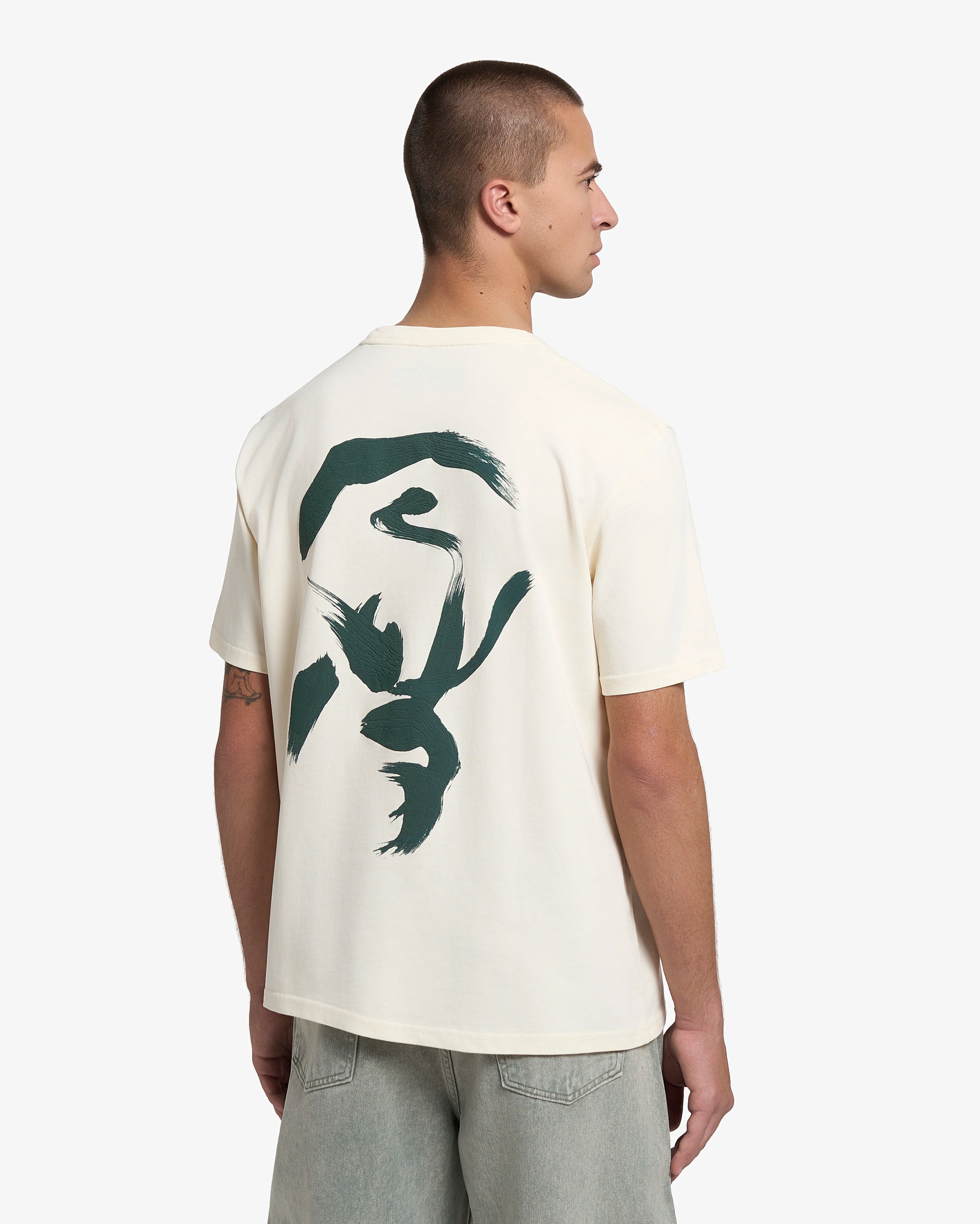 Artist edition featuring a hand-drawn design on the back, originally created on canvas
Short-sleeve t-shirt designed for everyday wear
Heavyweight 250 gsm 100% cotton jersey with a structured feel
Regular unisex fit
Off-white base colour with green graphic print on the front and back
Made in Portugal
