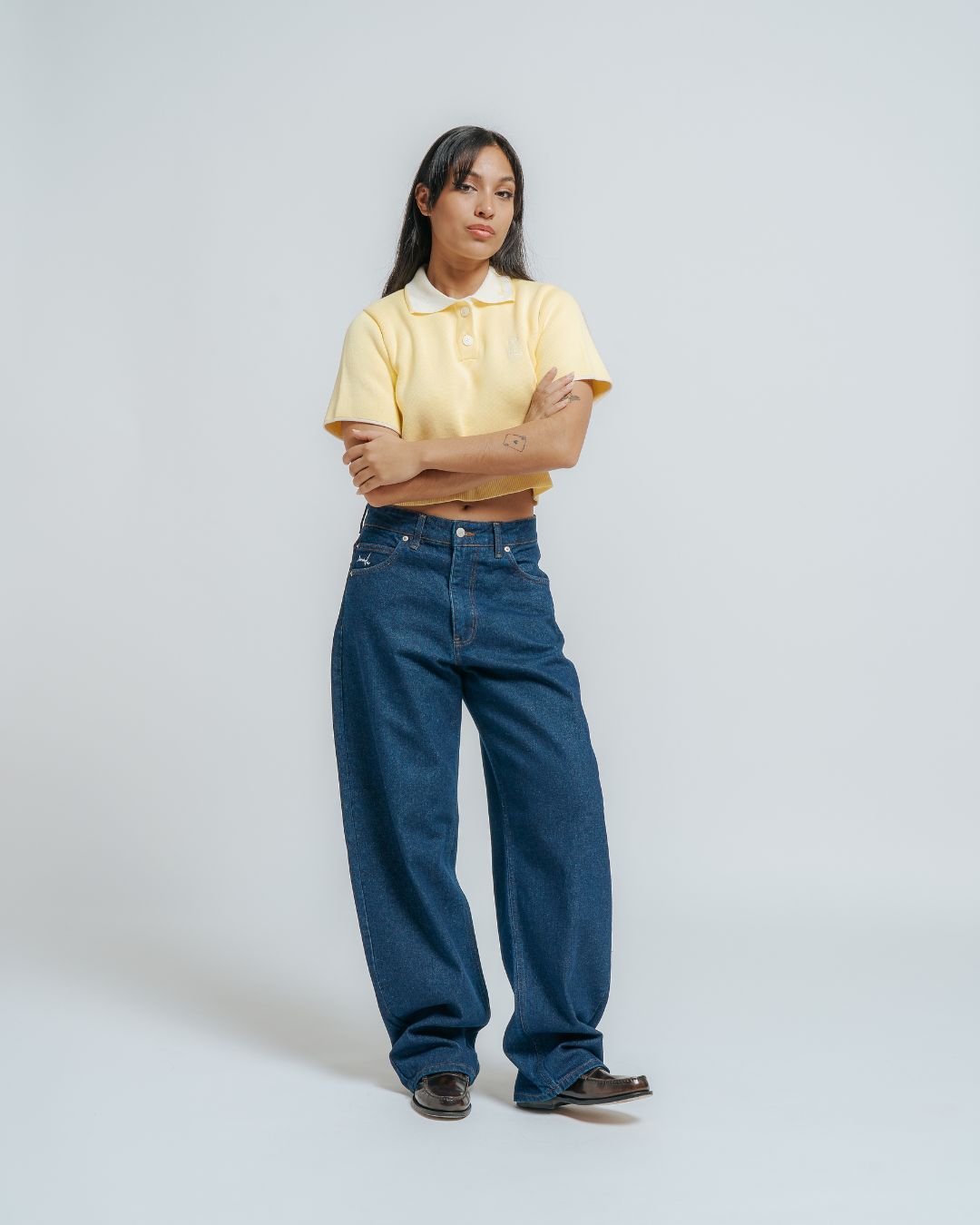 100% cotton knit
Butter colored fabric with off white contrasting details
Women's cropped fit
Classic polo collar in off white color
Two-button placket with matching cream buttons
Short sleeves with off white cuff trim
Ribbed hem for a clean finish
"Moved By Friendship" embroidery on the collar
Ikon logo embroidery on the left chest
Constructed from a soft knit fabric for a comfortable feel
Designed with a fitted silhouette that flatters the figure without being too tight
Brea
