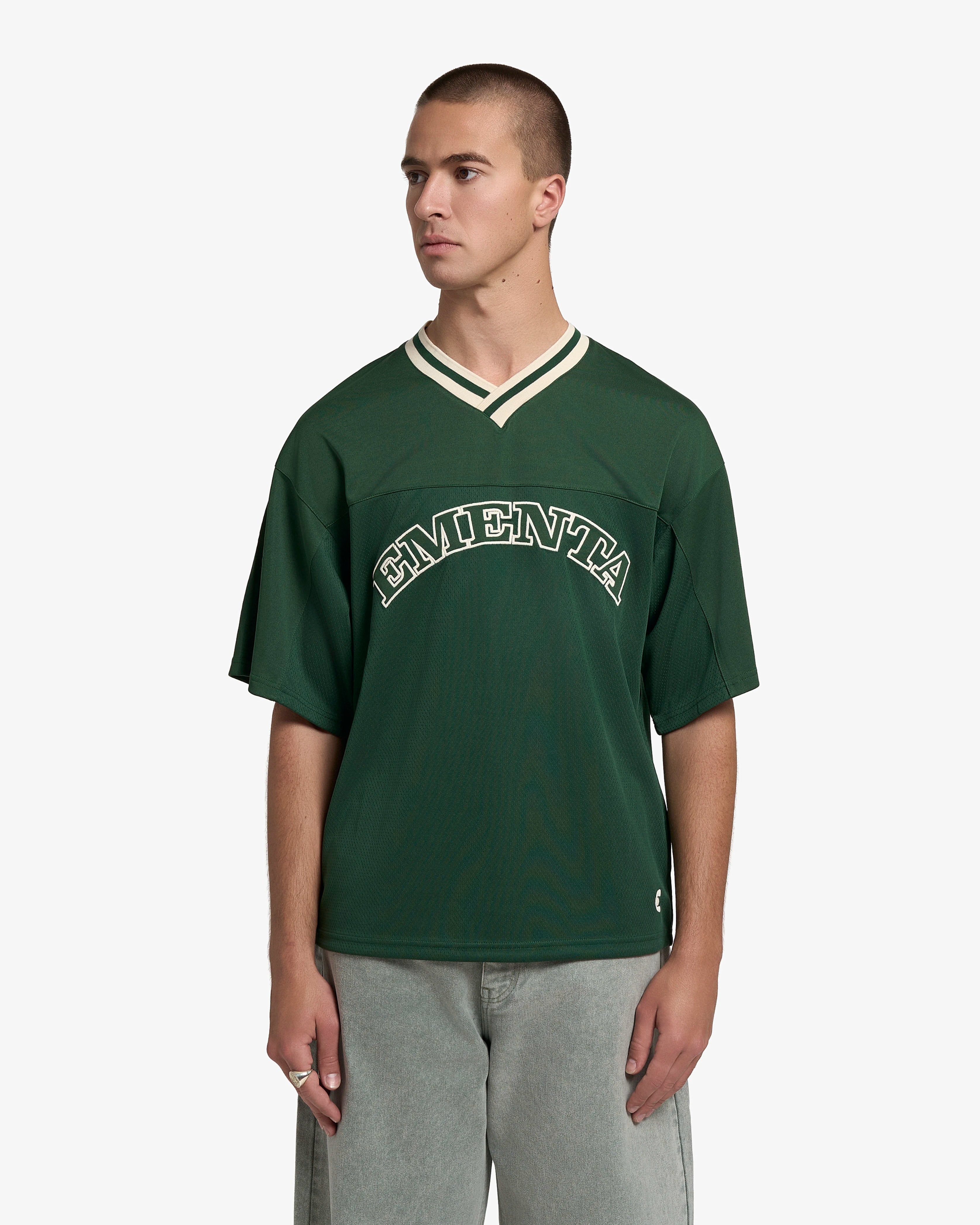 Breathable mesh fabric on the lower half, cotton-poly blend on the upper half
Oversized fit
Green color with off-white accents
Large 'EMENTA' embroidery on the chest, small branded detail embroidered on the bottom right
V-neck collar with double green stripes
Oversized sleeves for a relaxed silhouette
Part of a kit – matching shorts available online
Machine washable
