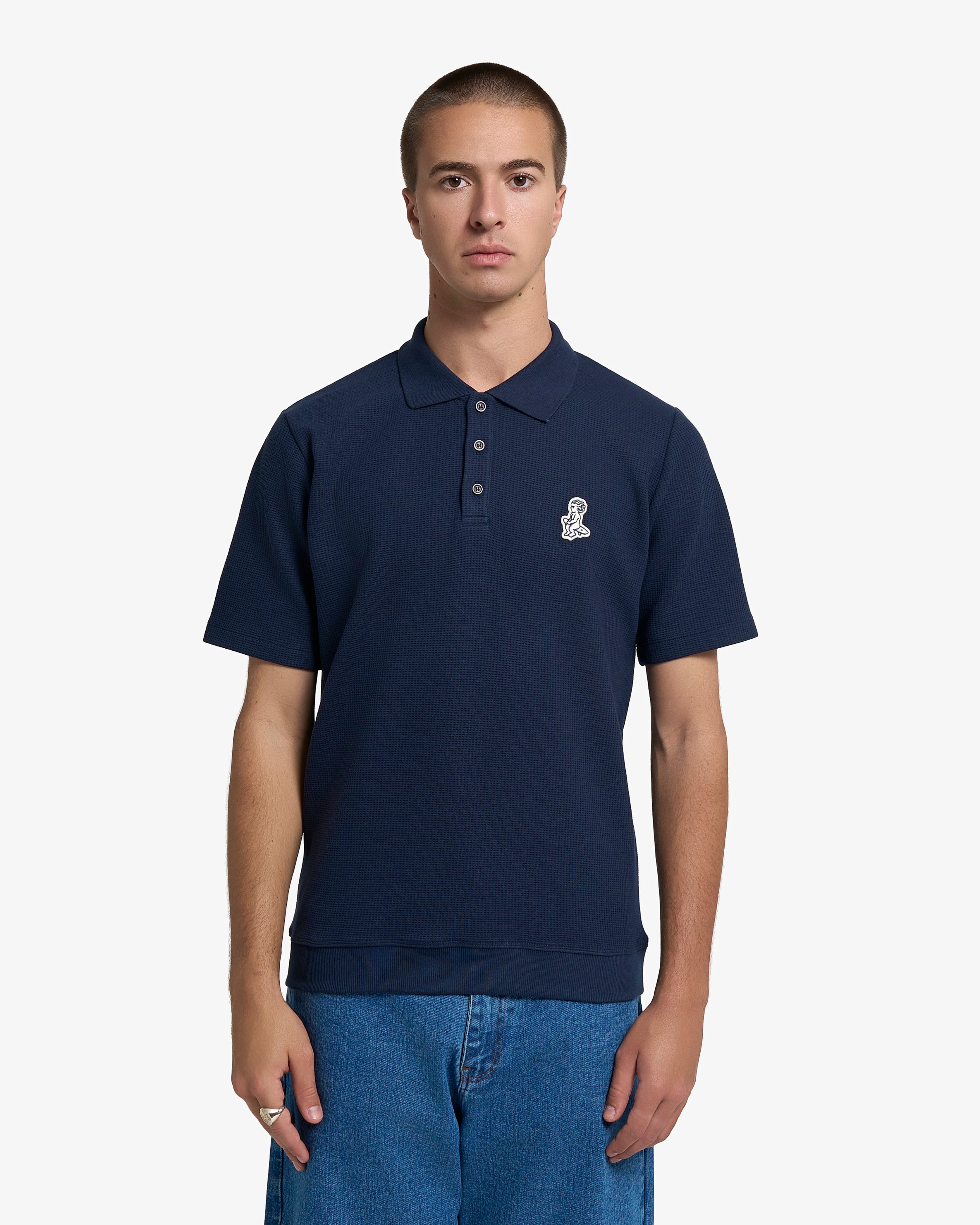 Ementa Polo Shirt
Waffle knit texture for enhanced breathability and structure
Ikon logo patch on the chest

Button-up front with four tonal buttons
Ribbed collar and sleeves
100% cotton
Regular fit
Unisex
Made in Portugal